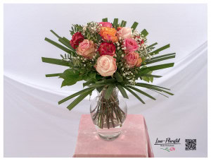 Blumenstrauß mit bunten Rosen, weißem Schleierkraut und Blätter der Stechpalme