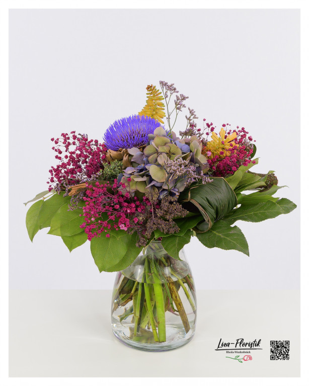 Rustikaler Strauß mit Artischockenblüte - blaue Hortensie, pinkes Schleierkraut, zarte Statice und die leuchtende Fackellilie vereinen sich zu einem farbenfrohen Kunstwerk.