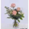 Blumenstrauß mit pfirsichrosa Rosen, weißem Lisianthus, Eukalyptus, weißem Schleierkraut, blauen Disteln und Phalaris.