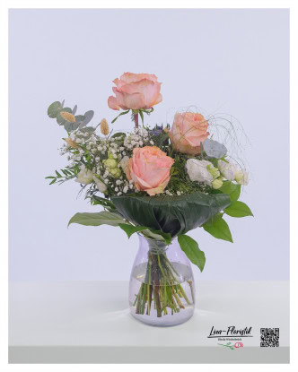 Blumenstrauß mit pfirsichrosa Rosen, weißem Lisianthus, Eukalyptus, weißem Schleierkraut, blauen Disteln und Phalaris.