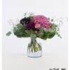 Dieser elegante Blumenstrauß kombiniert die dramatische Schönheit schwarzer Rosen mit der lebhaften Farbe einer pinken Hortensie, ergänzt durch das zarte Grün von Eukalyptus, die samtige Struktur der Celosia, die filigranen Akzente des Strandflieders und die verspielten Blüten von Nelken.