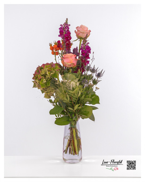 Gestaffelter Blumenstrauß mit Zierkohl, zarten apricotfarbenen Rosen, leuchtenden violetten Löwenmäulchen und lebhaften Hagebutten – ein echtes Highlight für jeden Anlass.