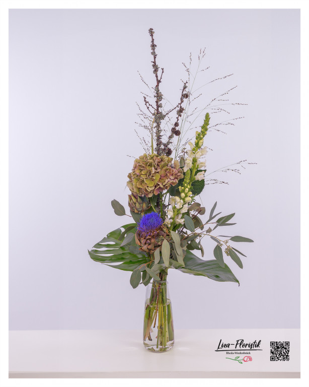 Exotische Protea, kräftige Hortensie und zarte Löwenmäulchen vereinen sich in diesem stilvollen Blumenstrauß zu einer harmonischen Komposition mit Eukalyptus und Monstera.