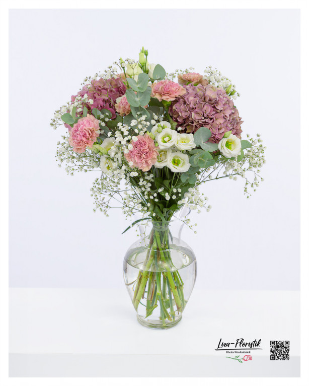 Dieser Blumenstrauß vereint zarte Lisianthus und Nelken in sanften Rosa- und Weißtönen mit prächtigen Hortensien und feinem Schleierkraut, ergänzt durch Eukalyptus, was eine harmonische und elegante Komposition schafft.