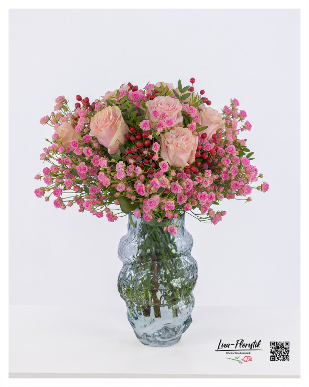 Zarter Blumenstrauß aus rosafarbenen Rosen, verspielten Polyantharosen und leuchtendem Hypericum – eine harmonische Komposition voller Eleganz.