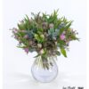 Blumenstrauß mit gefüllten lila Tulpen, zarten Wachsblumen und Eukalyptuszweigen, arrangiert mit frischem Grün.
