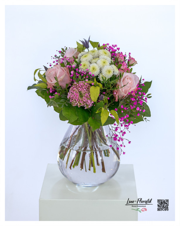 Blumenstrauß mit zartrosa Rosen, weißen Chrysanthemen, pinkem Schleierkraut, zarten Ranunkeln und frischem Grün, kunstvoll gebunden in einer harmonischen Farbkomposition.