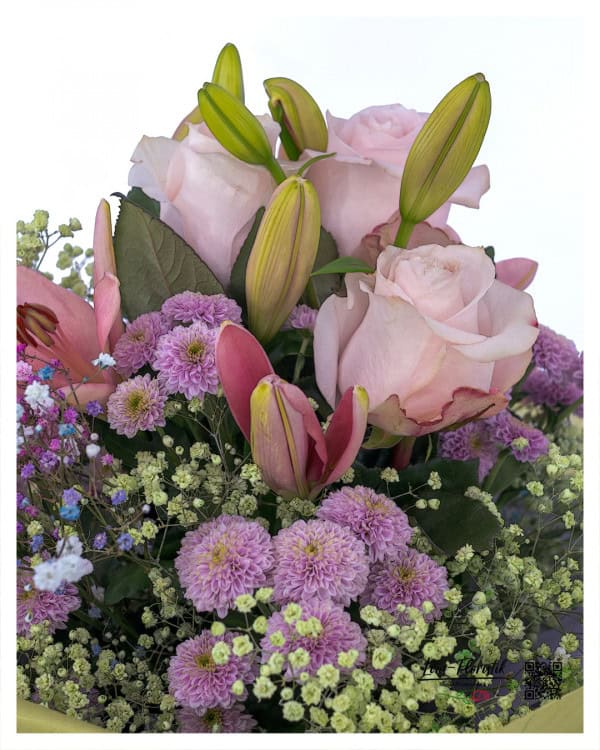 Nahaufnahme des Geburtstagsstraußes mit zartrosafarbenen Rosen, halb geöffneten rosa Lilien, violetten Chrysanthemen und feinem Schleierkraut – die strukturierte Blütenvielfalt und das harmonische Farbspiel sind im Detail besonders gut sichtbar.