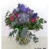 Üppiger Blumenstrauß mit lila Hortensien, pinken Rosen, violetten Lilien, blauem Rittersporn, Schleierkraut, Statice und frischem Eukalyptus – ideal als Geschenk oder Dekoration.