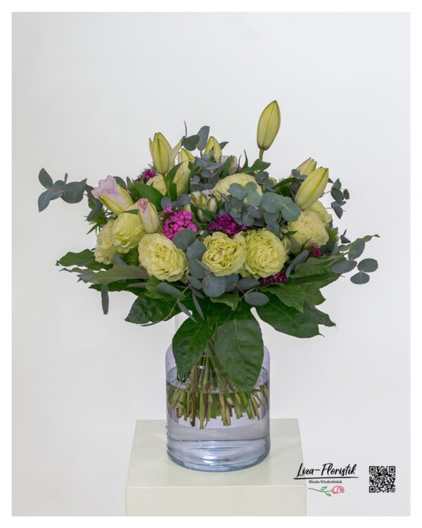Exklusiver Blumenstrauß mit hellgrünen Ecuador Rosen, rosa gefüllten Lilien, Bartnelken in kräftigem Violett und frischem Eukalyptus – rund gebunden mit edlem, dunkelgrünem Blattwerk.
