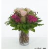 Blumenstrauß mit pinken Hortensien, zartrosa Ecuador Rosen der Sorte Pink Mondial, gefärbtem Ami, violetter Statice und luftigem Perückenstrauch, umgeben von kräftigem Grün.