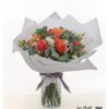 Apricot Blumenstrauß mit Rosen und Lisianthus in warmem Korallton, eingebettet in Eukalyptus und Schleierkraut