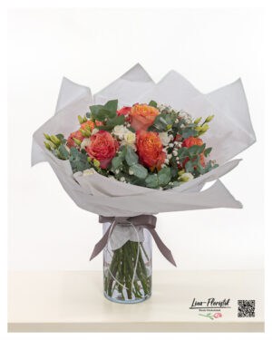 Apricot Blumenstrauß mit Rosen und Lisianthus in warmem Korallton, eingebettet in Eukalyptus und Schleierkraut