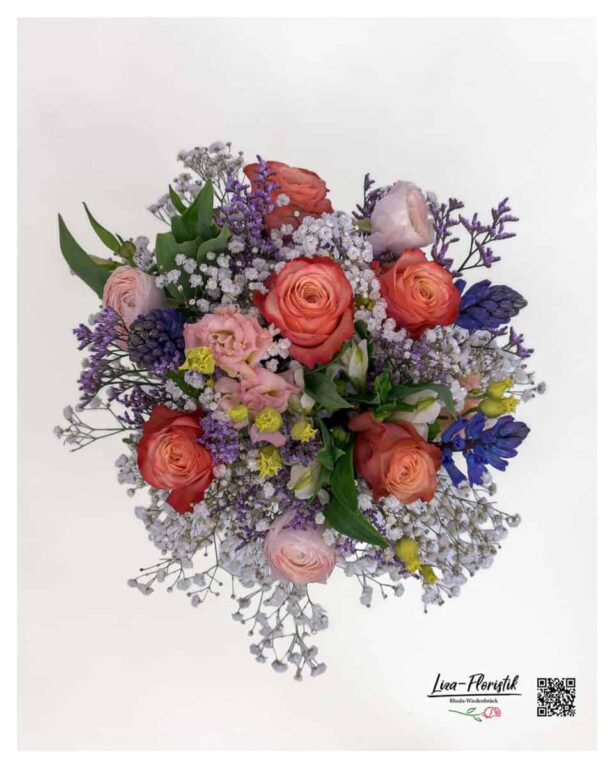 Detailansicht von Rosen, Ranunkeln und Hyazinthen mit feinem Schleierkraut in lebendigen Farben.