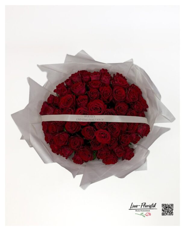 Rund gebundener Rosenstrauß in weißem Seidenpapier und bedruckter Schleife – Ansicht von oben